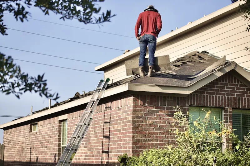 Professional roofer working on a residential roof in Knolls West